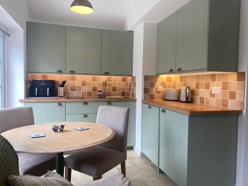 a kitchen with a table and chairs and a counter top at Brambling Fields B&B and Cottages in Malton