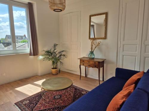 un salon avec un canapé bleu et une table dans l'établissement Le prospère - wifi - central, à Angers