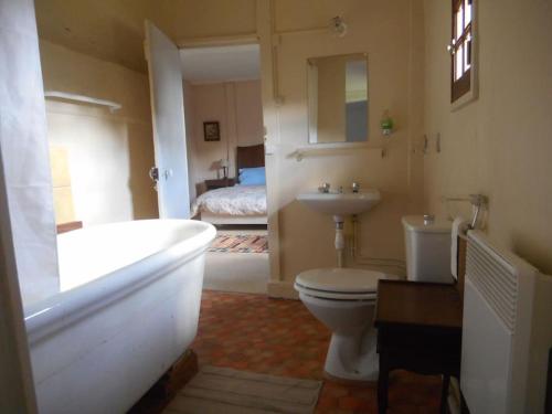une salle de bain avec une baignoire, des toilettes et un lavabo dans l'établissement La Ferme du Chateau, à Fauguernon