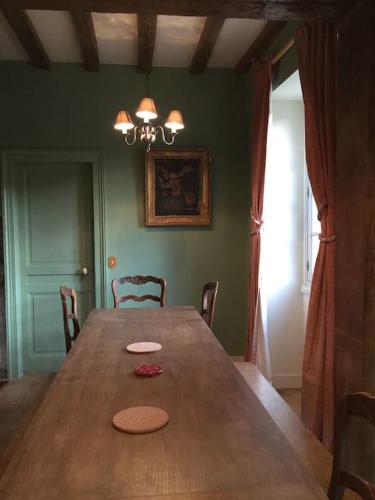 une salle à manger avec une table en bois et des chaises dans l'établissement La Ferme du Chateau, à Fauguernon