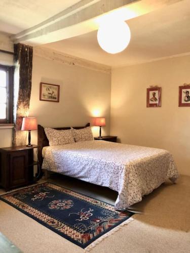 - une chambre avec un lit, deux lampes et un tapis dans l'établissement La Ferme du Chateau, à Fauguernon