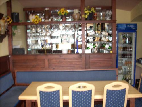 a table and chairs in a restaurant with a bar at Penzion U Račáku in Frymburk