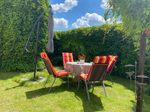 einen Tisch mit vier Stühlen und einem Sonnenschirm in der Unterkunft Ferienwohnung Thiel in Neumark