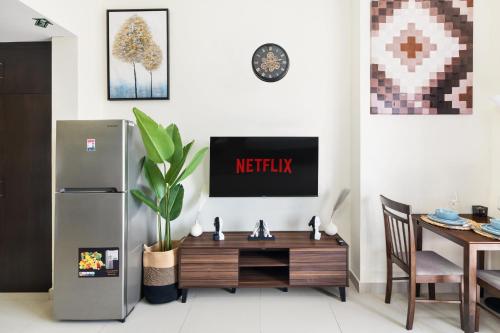 a kitchen with a refrigerator and a wooden table at Modern Studio Sports City Pool & City Views in Dubai