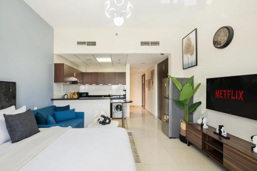 a bedroom with a large bed and a kitchen at Modern Studio Sports City Pool & City Views in Dubai