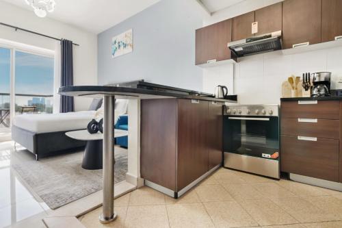 a kitchen with a table and a living room at Modern Studio Sports City Pool & City Views in Dubai