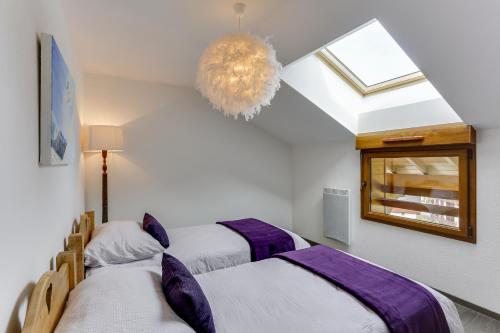 - 2 lits dans une chambre avec une fenêtre et un lustre dans l'établissement Bellevue BL42 CHARMING & MOUNTAIN 6 Pers, à Châtel