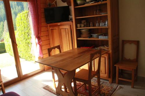- une table et des chaises en bois dans une chambre avec fenêtre dans l'établissement Chalet de l'Oy OY2 NATURE & MOUNTAIN 3 pers, à Châtel