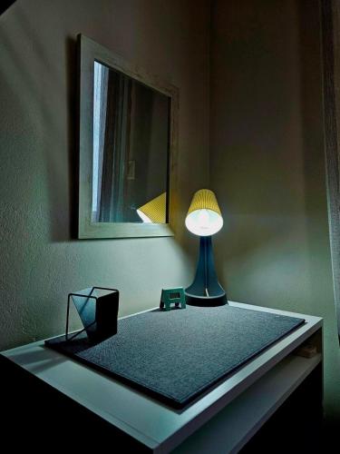 a lamp on a table in a room with a mirror at VMA Residence - near Airport & Beach in Artemida