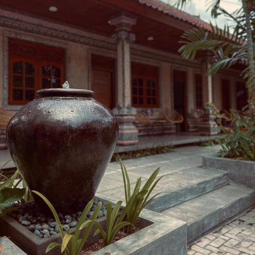 a large vase sitting in front of a building at Kaman Bali Guesthouse in Seminyak