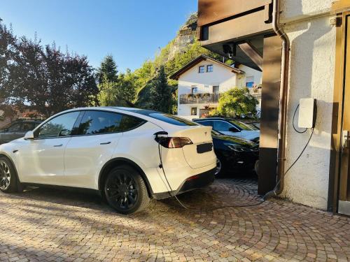 a white car is plugged into a building at Garni Marianne in Malles Venosta