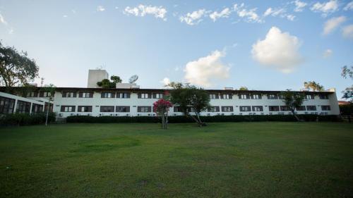 a large white building with a large grass yard at Hotel Fazenda Portal de Gravatá in Gravatá