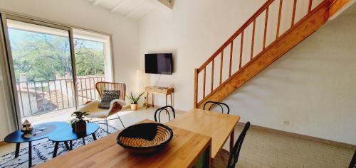 un salon avec une table et des chaises et un escalier dans l'établissement Grand T2 Le Bohème, à Perpignan