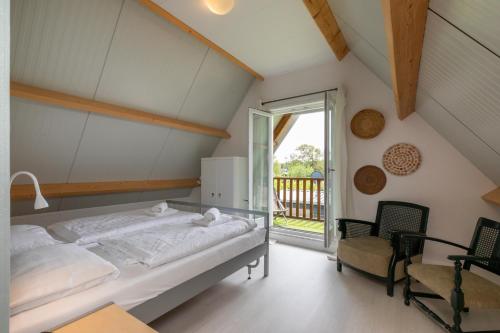 Un dormitorio con una cama y un balcón. en Welcome in - Vakantiewoning - Horizon 14 - Renesse, en Renesse