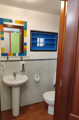 a bathroom with a sink and a toilet and a mirror at A Casiña do Río in Neda