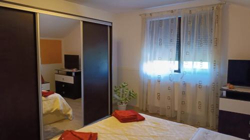 een slaapkamer met een spiegel, een bed en een raam bij Casa Mirela in Boekarest