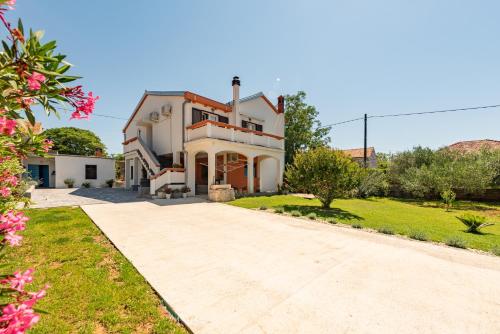 a large white house with a driveway at Apartman Mara in Poljica