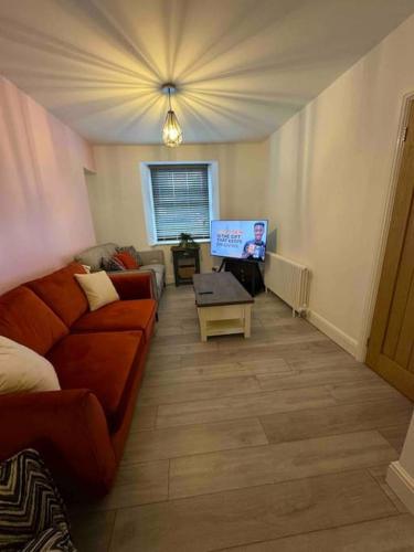 a living room with a couch and a tv at Quaint cottage close to Marina in Pembrokeshire