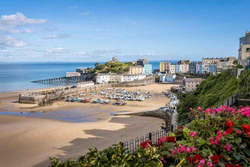 a view of a beach with a pier and the ocean at Quaint cottage close to Marina in Pembrokeshire