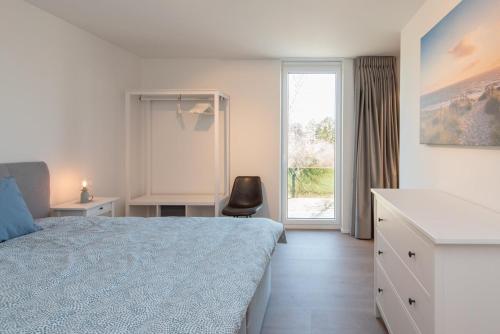 une chambre avec un lit, un bureau et une fenêtre dans l'établissement Villa Petit Mouche - Recently renovated villa close to beach, à Coxyde