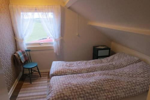 - une petite chambre avec un lit et une fenêtre dans l'établissement Borghildstua Feriehus, à Melbu