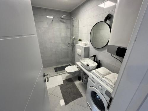 a bathroom with a toilet and a sink and a mirror at Eva Luxury Rooms & Apartments in Plitvička Jezera