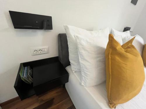 a couch with two pillows and a tv on the wall at Eva Luxury Rooms & Apartments in Plitvička Jezera