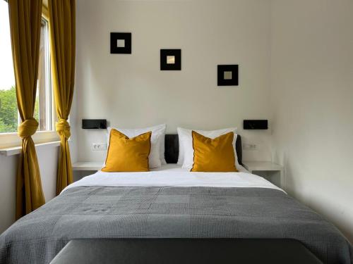 a bedroom with a bed with yellow pillows and a window at Eva Luxury Rooms & Apartments in Plitvička Jezera