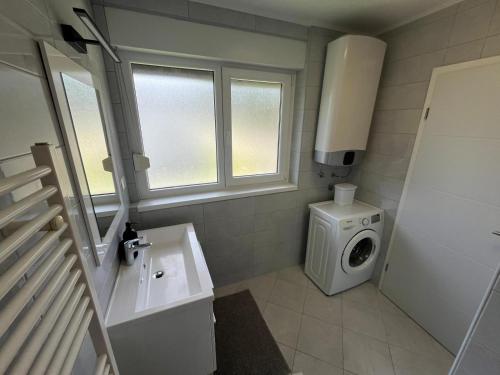 a bathroom with a washing machine and a washer at Eva Luxury Rooms & Apartments in Plitvička Jezera