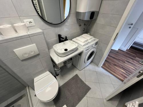 a bathroom with a toilet and a washing machine at Eva Luxury Rooms & Apartments in Plitvička Jezera