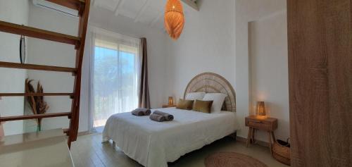 une chambre avec un lit et une grande fenêtre dans l'établissement Grand T2 Le Bohème, à Perpignan