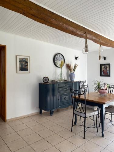 une salle à manger avec une table et une horloge au mur dans l'établissement Au pré vert, à Acheux-en-Vimeu