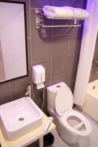a bathroom with a white toilet and a sink at Eurotel Pedro Gil in Manila