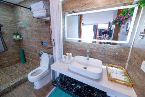 a bathroom with a sink and a toilet and a mirror at Lijiang Old Town Meiliju View Inn in Lijiang