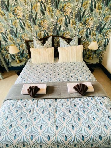 a bedroom with a blue and white bed with pillows at Auberge du Relais d'Auniac - Hôtel Bar Restaurant Piscine in Anglars-Nozac
