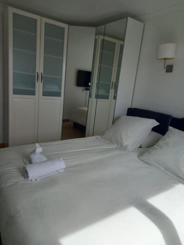 une chambre avec un lit blanc avec des serviettes dessus dans l'établissement Superbe appartement à Paris, à Puteaux