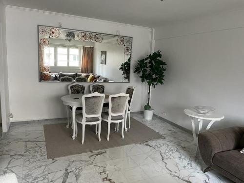 un salon blanc avec une table et des chaises dans l'établissement Superbe appartement à Paris, à Puteaux