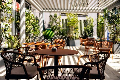 an outdoor patio with tables and chairs and plants at Urban Hive Milano in Milan