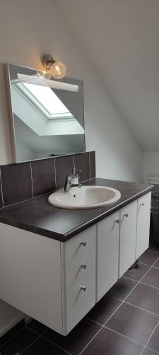 une salle de bain avec un lavabo et un miroir dans l'établissement So'Home, à Saint-Père