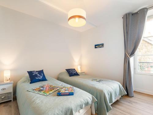 deux lits jumeaux dans une chambre avec fenêtre dans l'établissement Apartment L'Emerillon by Interhome, à Dinard
