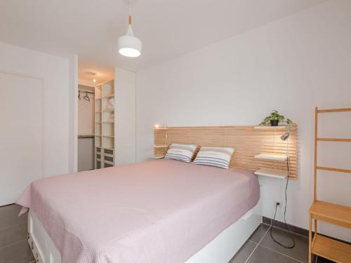 une chambre avec un grand lit avec une tête de lit en bois dans l'établissement Apartment Le Newport-3 by Interhome, à Fréjus