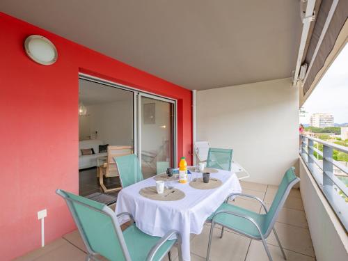 une salle à manger avec une table et des chaises sur un balcon dans l'établissement Apartment Le Newport-3 by Interhome, à Fréjus