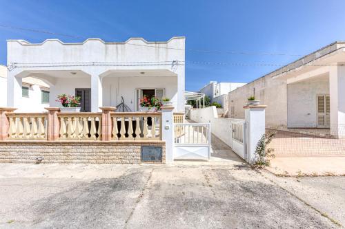 a white house with a balcony with flowers on it at Dimora Ristola in Leuca