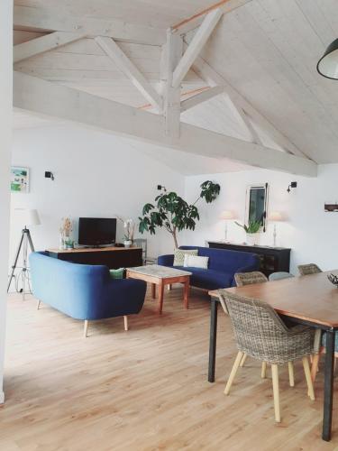 - un salon avec des chaises bleues et un piano dans l'établissement Villa avec piscine chauffée, à Sainte-Marie de Ré