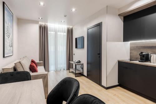 a living room with a table and chairs and a kitchen at Glacier Premium Apartments in Bukovel