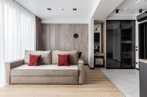a living room with a couch with two red pillows at Glacier Premium Apartments in Bukovel