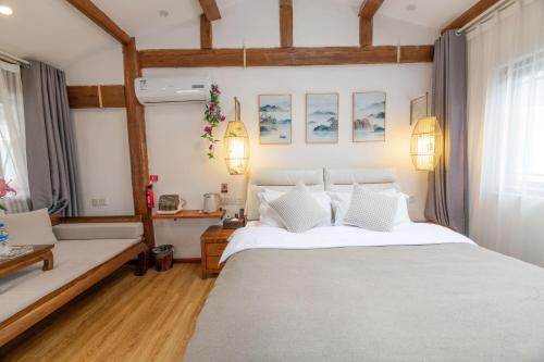 a bedroom with a large white bed and a couch at Lijiang Old Town Meiliju View Inn in Lijiang