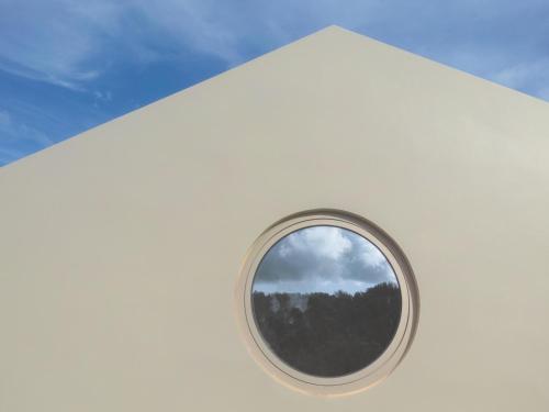 a round window on the side of a white airplane at Casa nas Caldeiras in Furnas