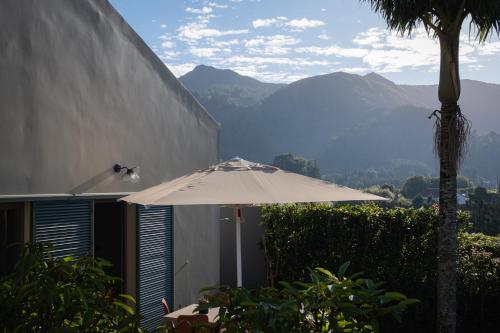 a white umbrella sitting in front of a building at Casa nas Caldeiras in Furnas