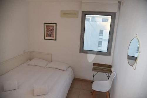 une chambre blanche avec un lit et un miroir dans l'établissement Proche Montpellier, T3, 2 chambres, parking, tram, à Castelnau-le-Lez